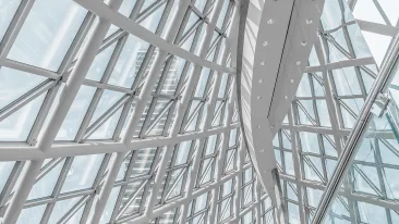 Rakennuksen valkoiset ikkunarakenteet kaartuvat muodostaen kuvulta näyttävän pinnan.