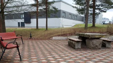 Mäkisellä piha-alueella on laatoitettu oleskelutila, jossa on erilaisia istuma- ja levähdyspaikkoja.