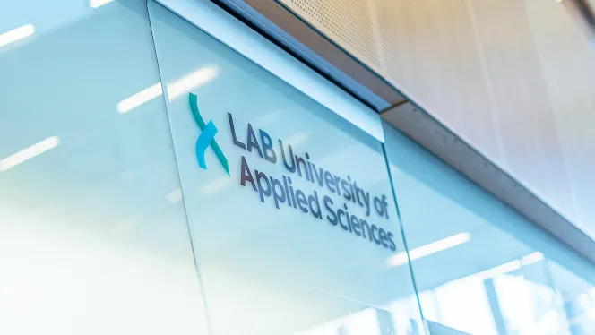 LAB-ammattikorkeakoulun logo on teipattu läpikuultavaan lasiseinään.