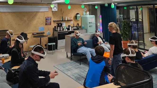 Joukko nuoria istuu avarassa tilassa sohvaryhmillä VR-lasit päässään.