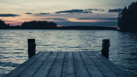 Laiturinnokka iltahämärässä auringonlaskun aikaan.