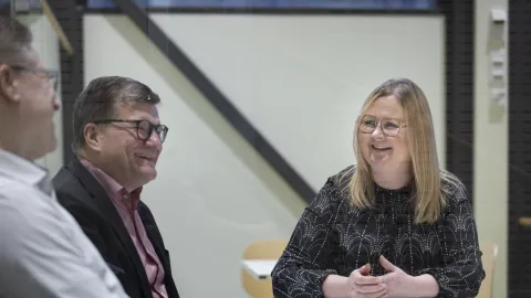 Henkilöt keskustelevat pöydän ääressä istuen.